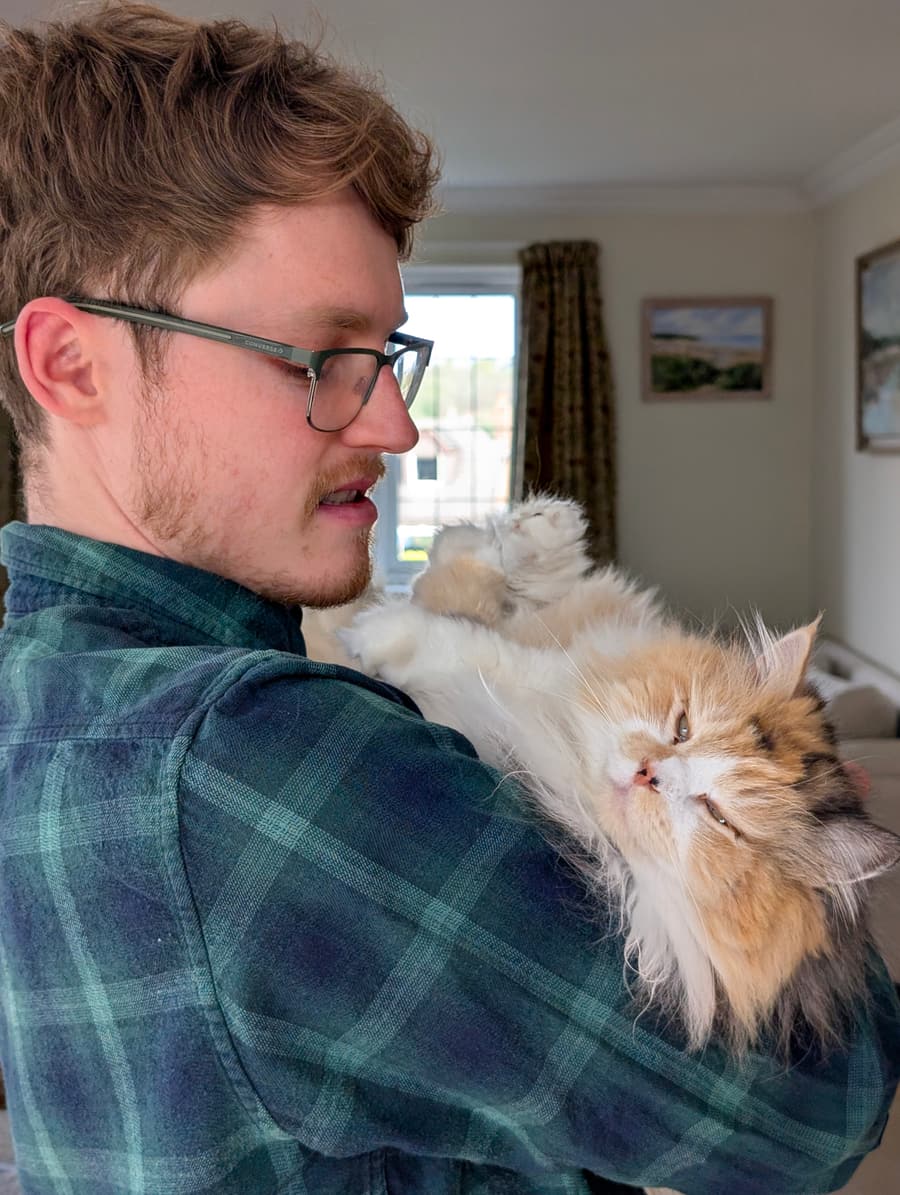 Aaron holding a long-haired calico cat