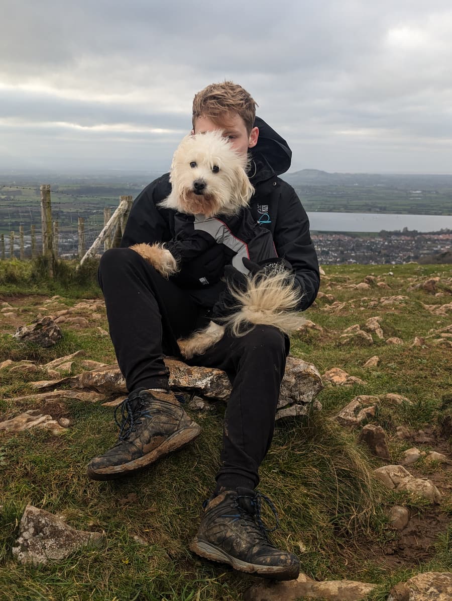 Aaron on a hilltop walk with a small white dog